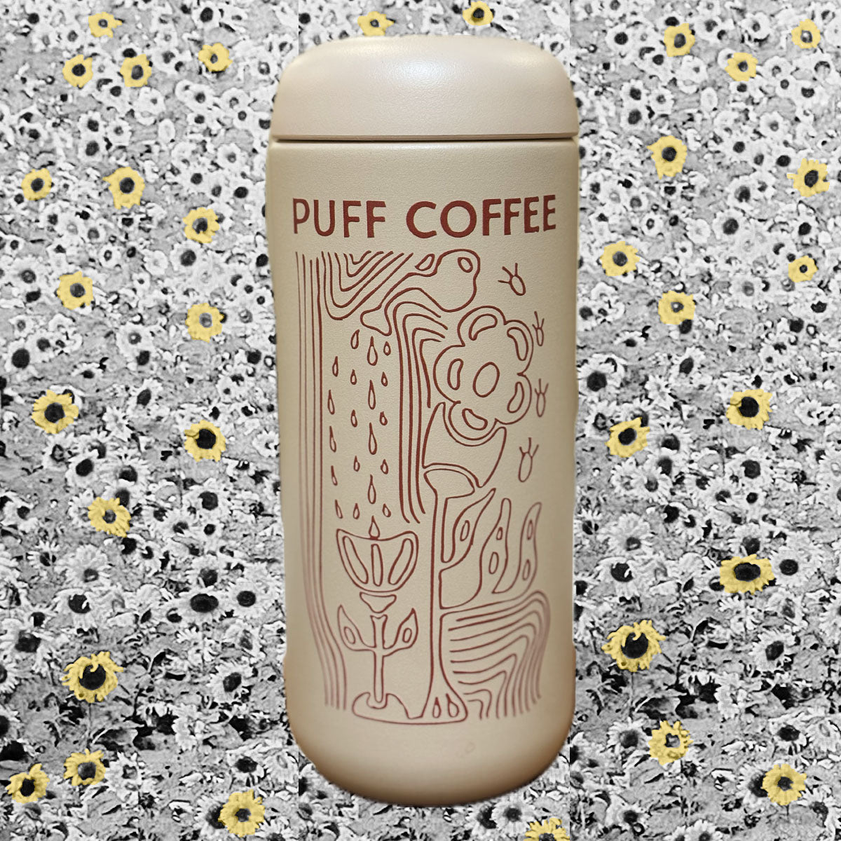 Beige coffee tumbler with 'Puff Coffee' branding on a floral patterned background