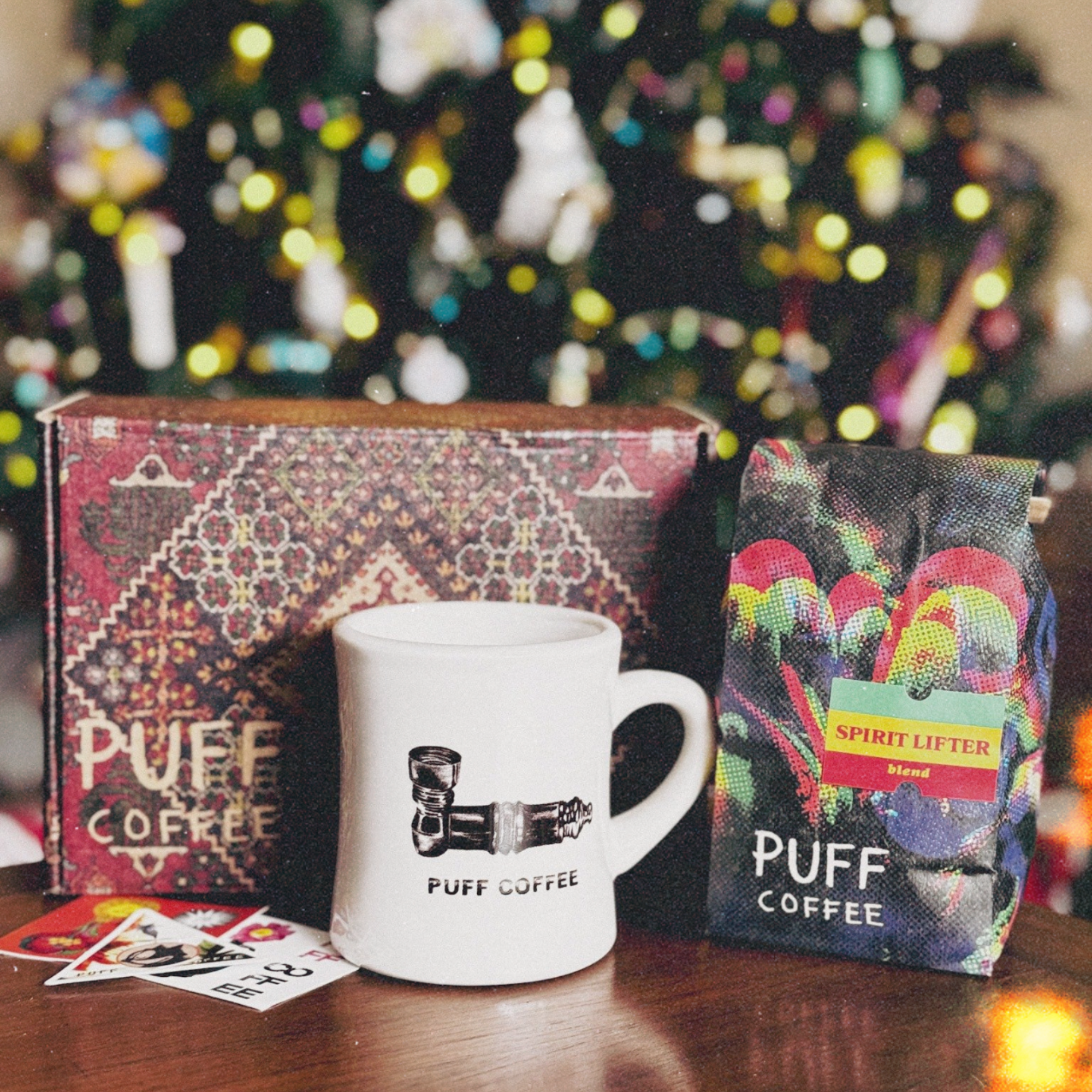 Puff Coffee mug and gift box with a Christmas tree in the background