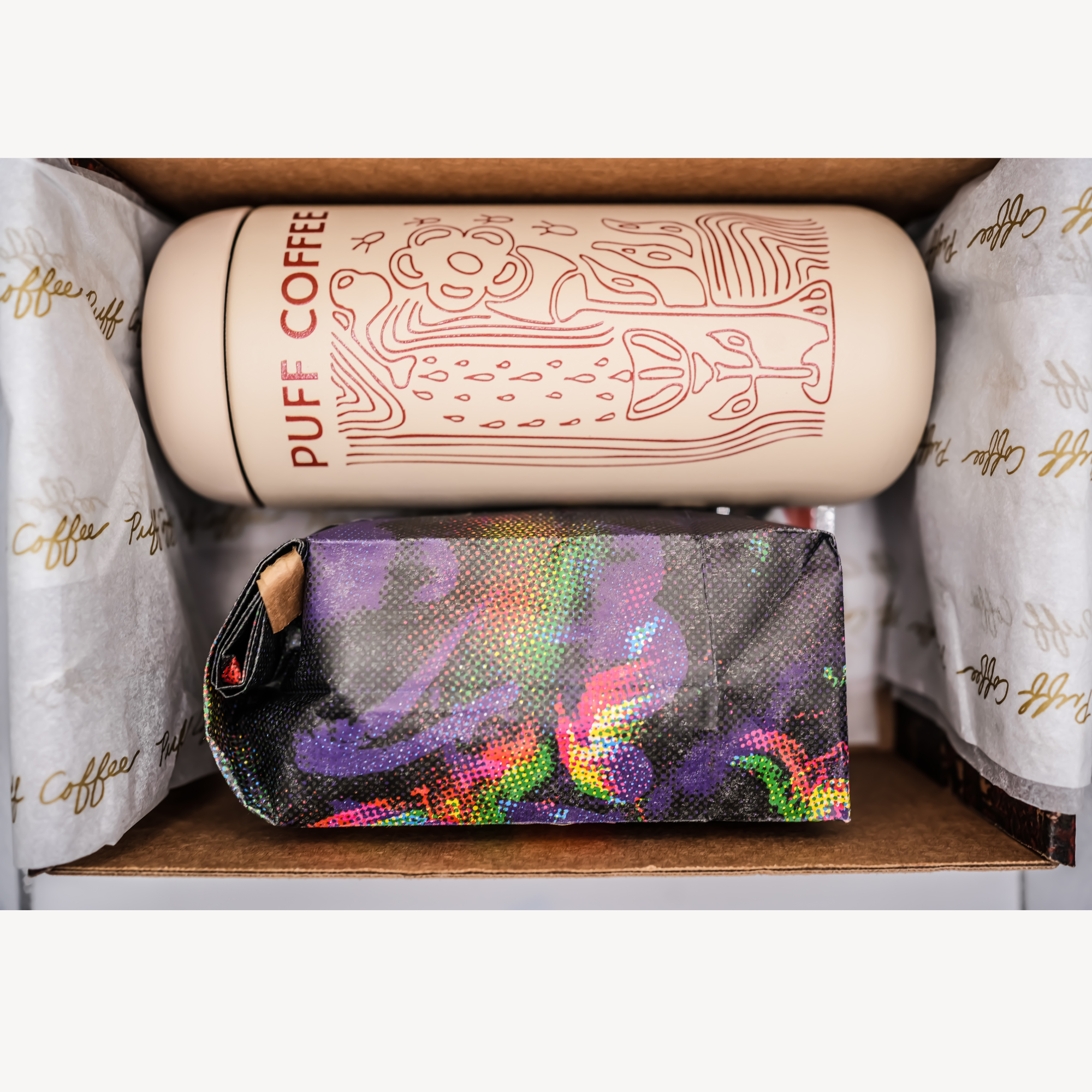 Puff Coffee bag of coffee with a sand colored, patterned travel mug  in a gift box.